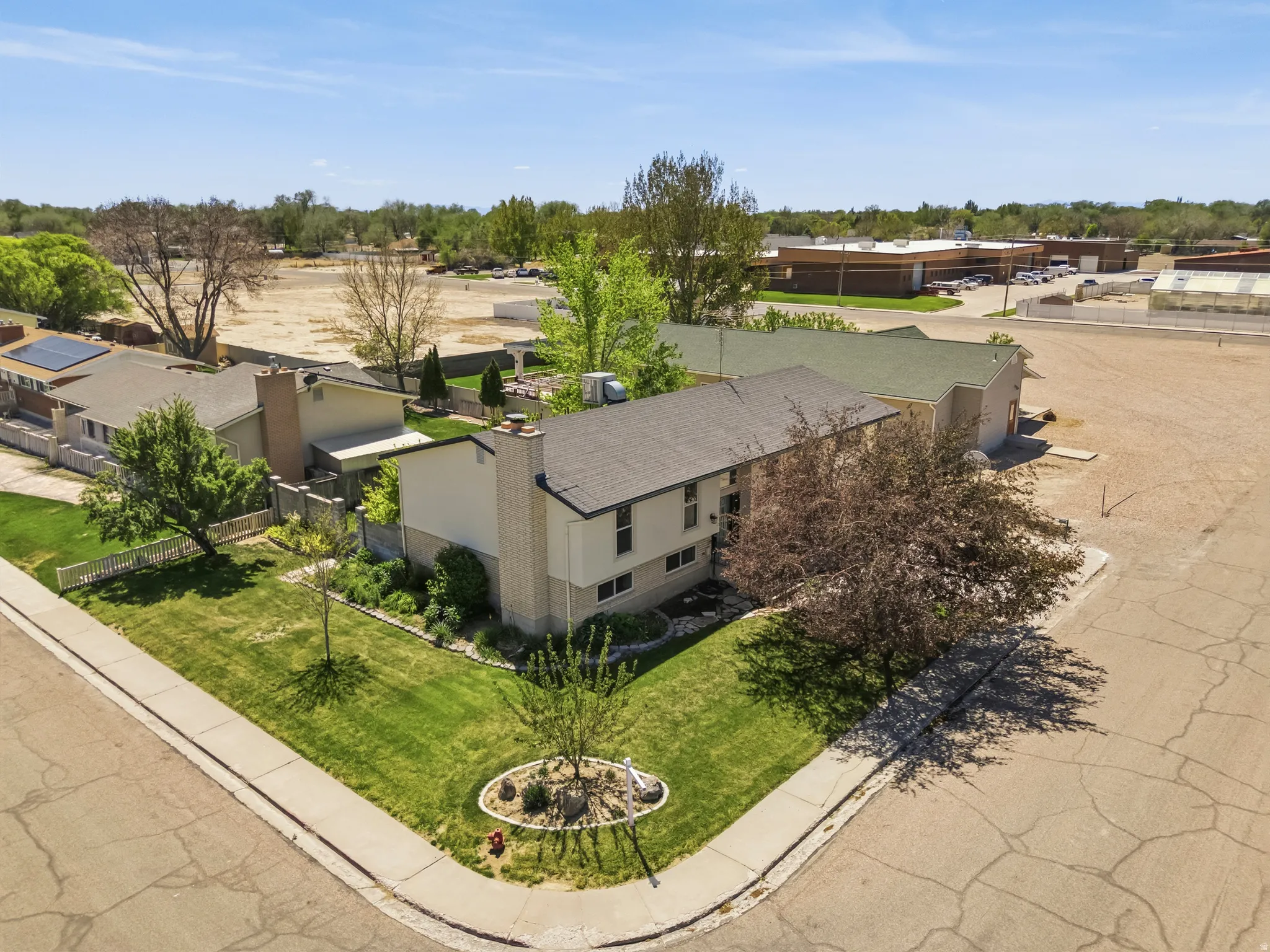 Corner lot residence featuring a well-maintained lawn and mature trees