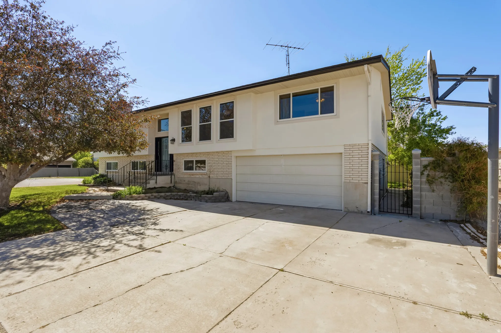 Two-story exterior with a two-car garage, light-colored siding, and white brick accents
