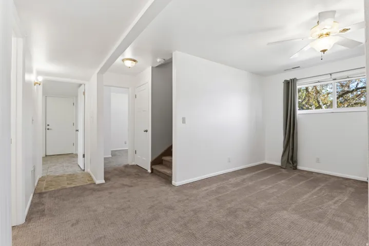 Spacious room featuring neutral carpeting, white walls, and a multi-pane window