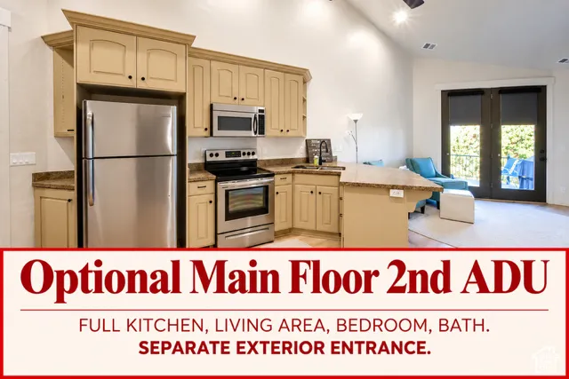 Kitchen featuring shaker-style cabinetry, stone-finish countertops, stainless steel appliances, built-in microwave, and vaulted ceilings