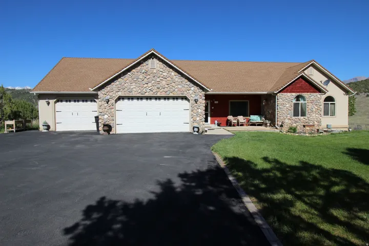 Elegant ranch style home with stone and stucco exterior with a prominent three-car garage
