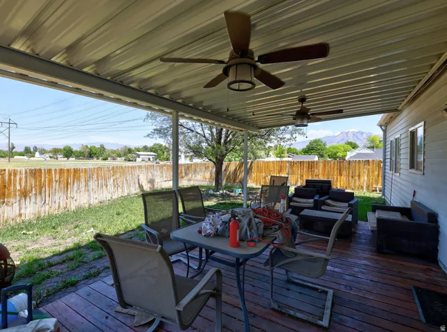 Expansive covered deck featuring wood plank flooring and two ceiling fans