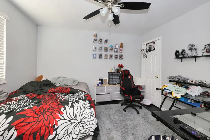 Room featuring neutral wall tones, a ceiling fan with integrated lighting, and wood-finish flooring