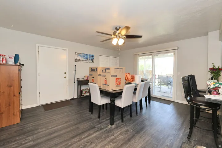 Spacious interior featuring wood-finish flooring, a ceiling fan with integrated lighting, and a sliding glass door providing access to the patio