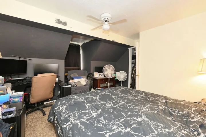 Bedroom featuring a ceiling fan, light-toned walls, and a closet with a white door