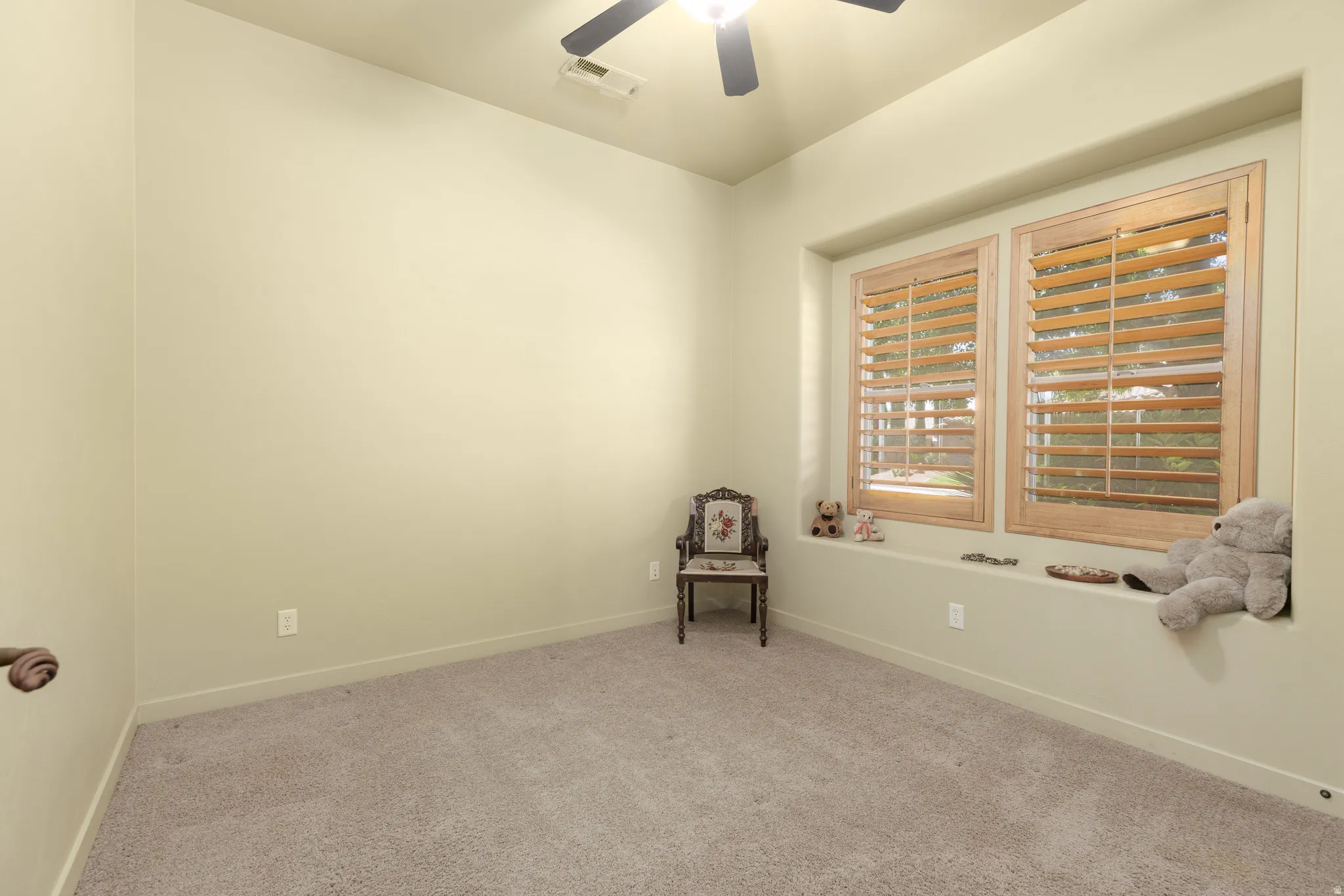 Recessed window area featuring two windows with wood plantation shutters and a deep sill