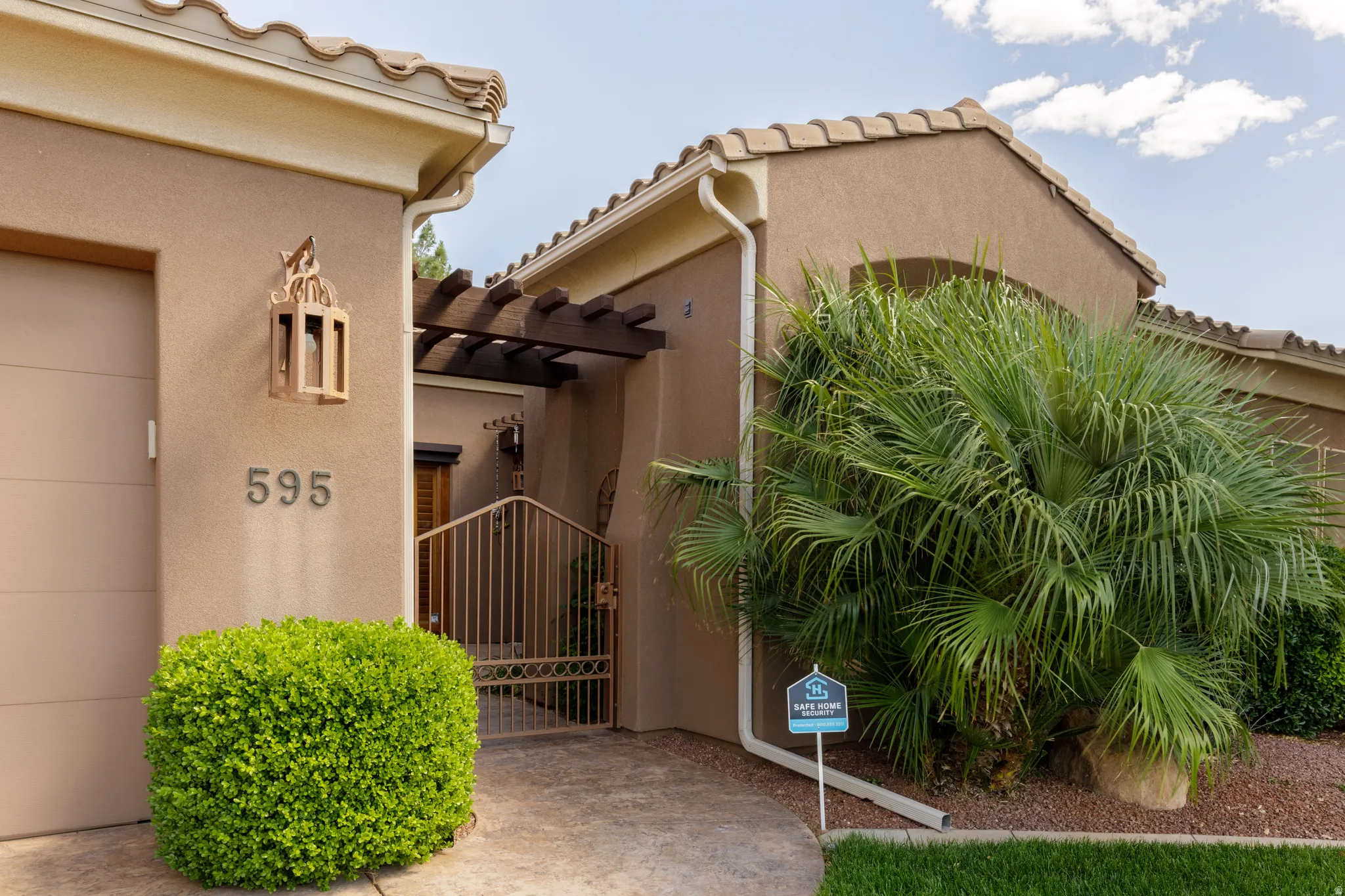 Stucco exterior featuring a tiled roof and a decorative pergola
