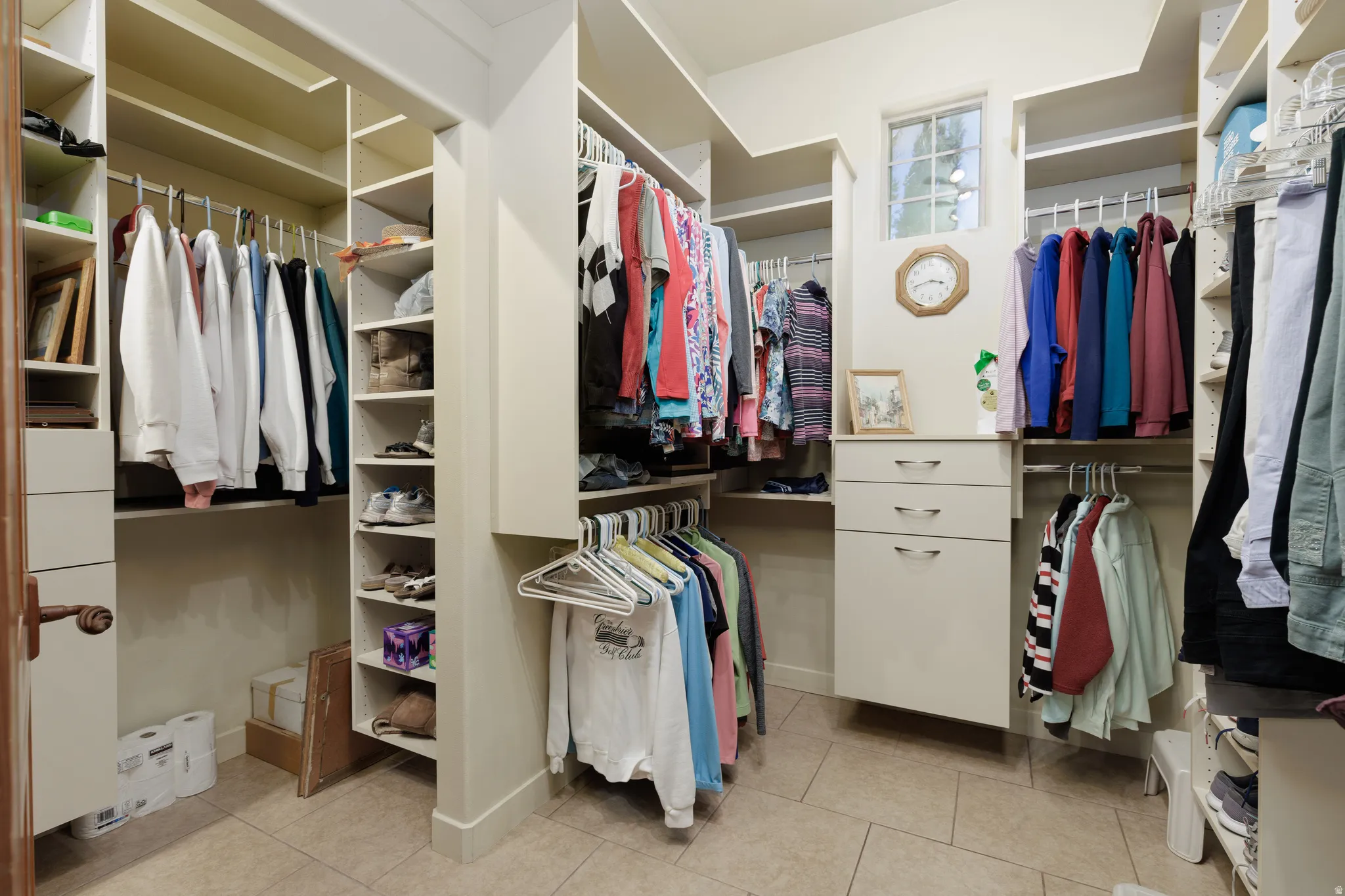 Expansive walk-in closet featuring extensive built-in shelving, multiple hanging rods, and integrated drawer storage
