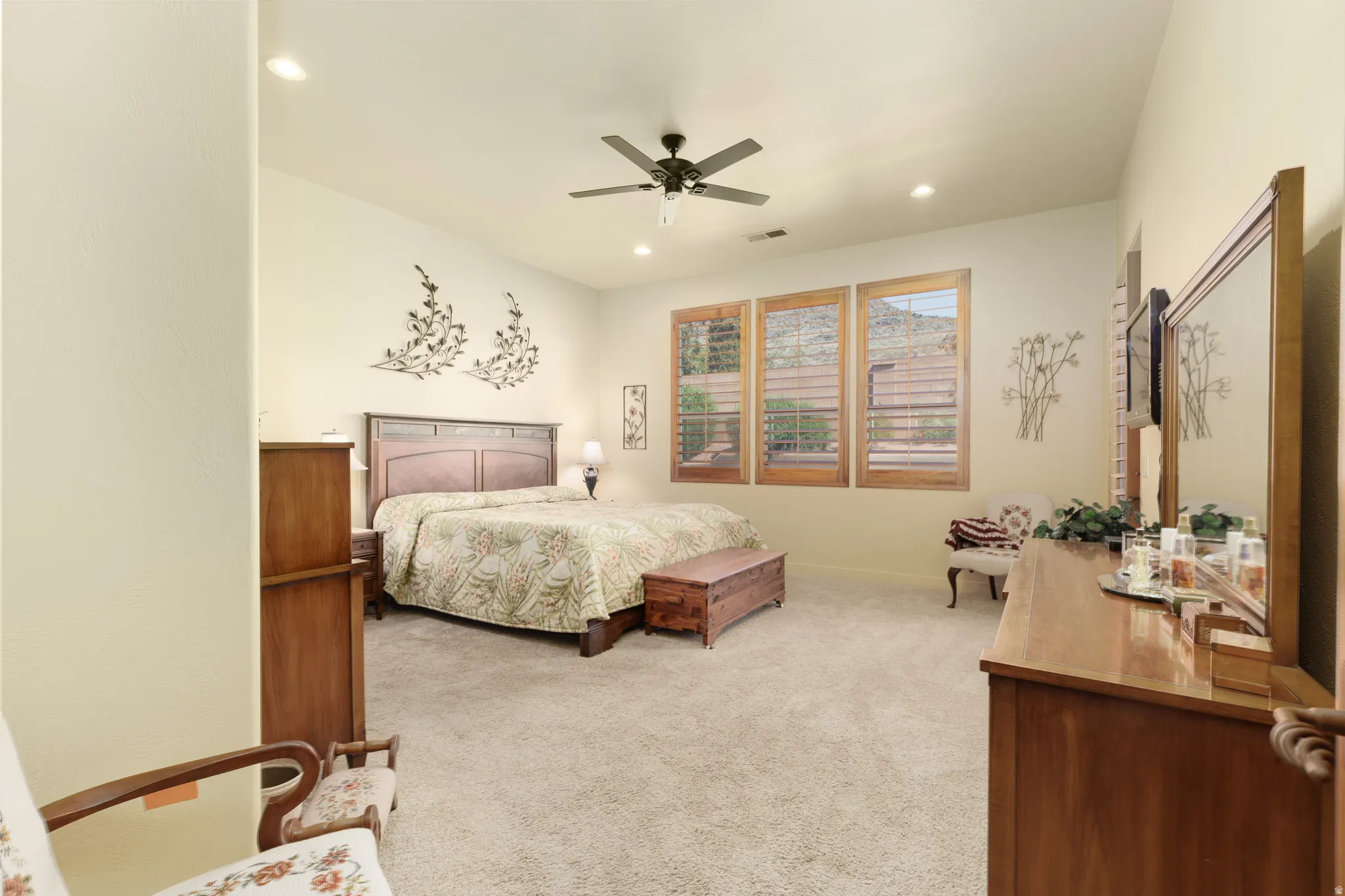 Bright interior space featuring three large windows, a ceiling fan, and recessed lighting