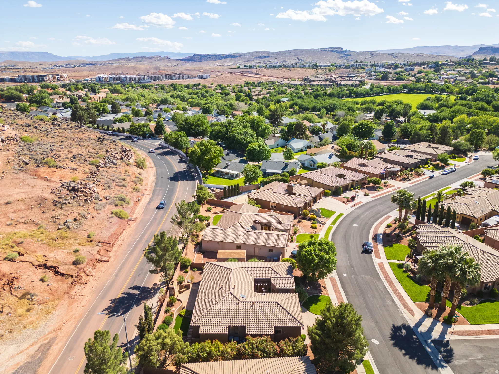 Residential neighborhood featuring varied architecture, paved roads, and mature landscaping