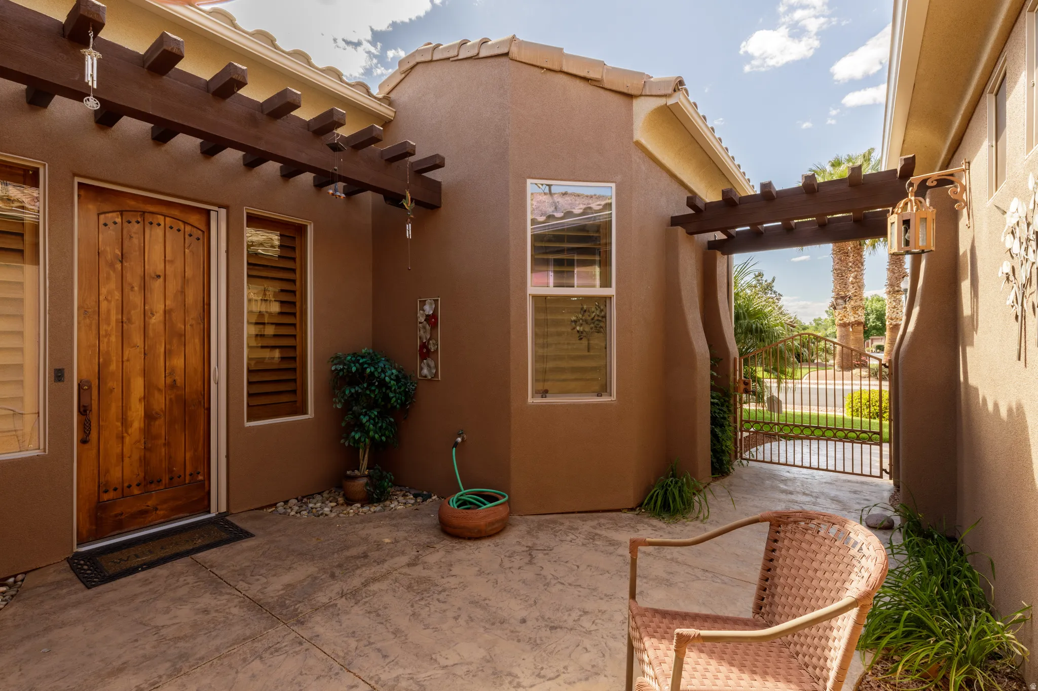Entry courtyard featuring stamped concrete and a decorative wood pergola