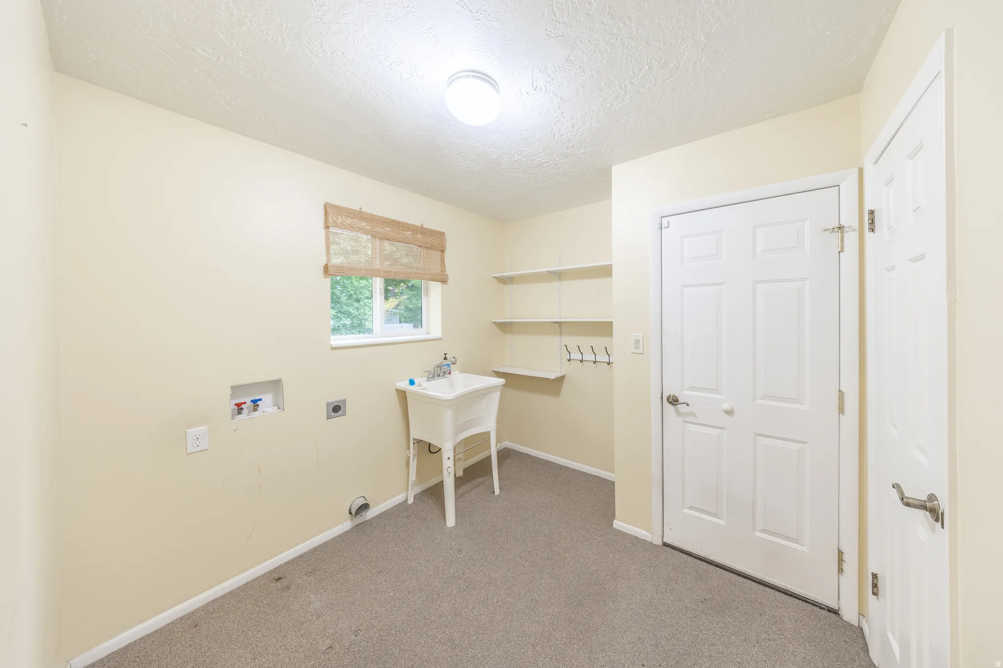 Main floor laundry with sink and access to garage