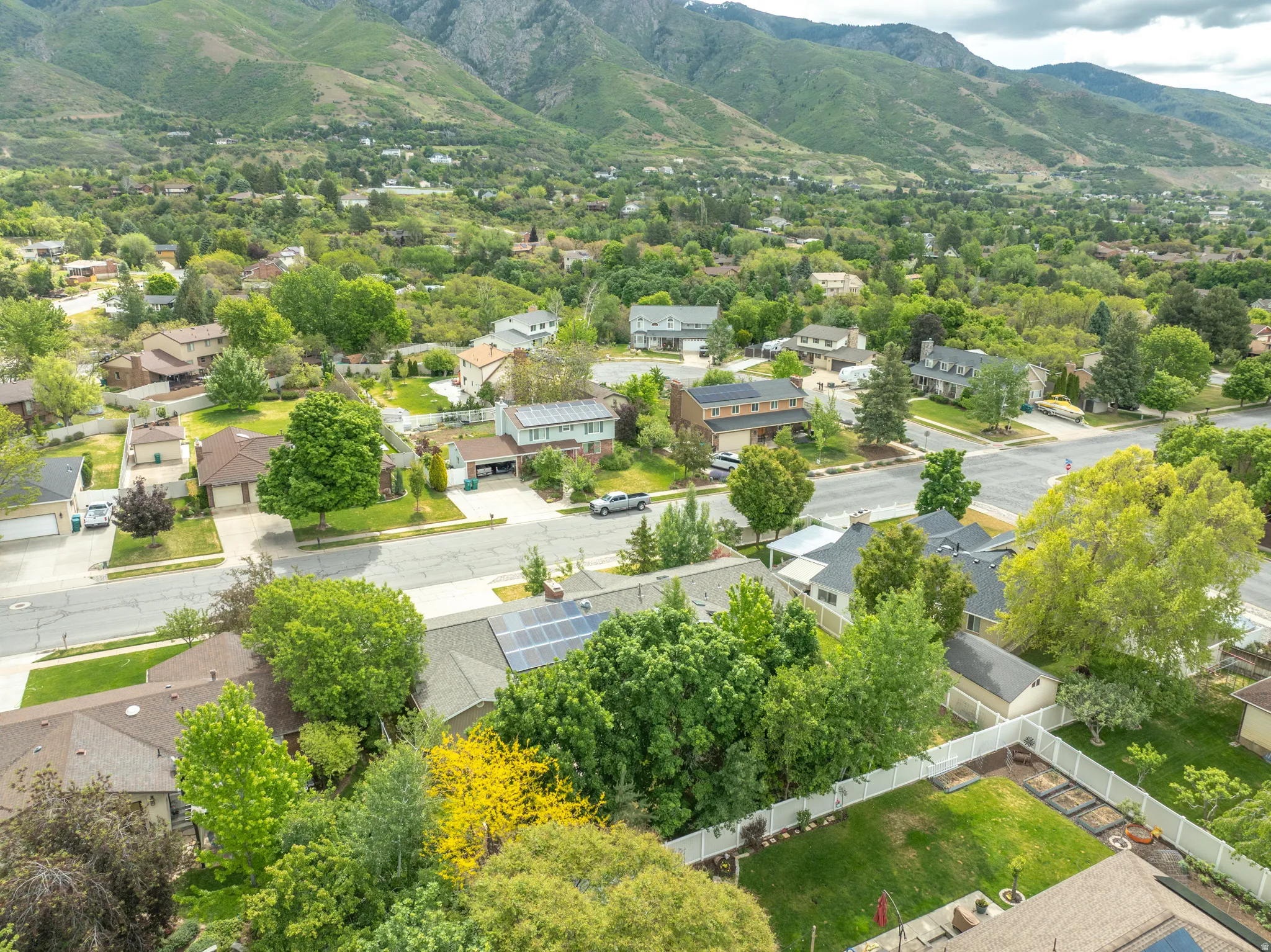 Expansive residential area featuring established homes, mature trees, and mountainous terrain