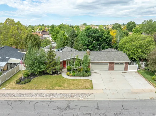 Brick-front residence featuring an attached two-car garage, a concrete driveway, and a front walk leading to a red entry door