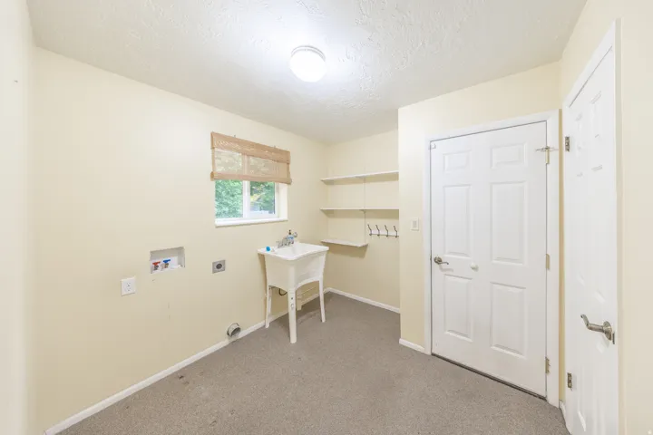 Main floor laundry with sink and access to garage