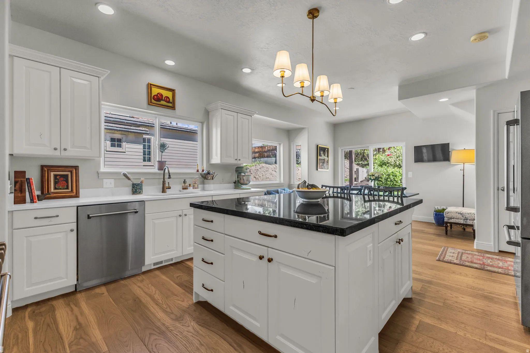 Spacious eat-in kitchen with granite and quartz, a hidden pantry, and a balcony to the backyard.