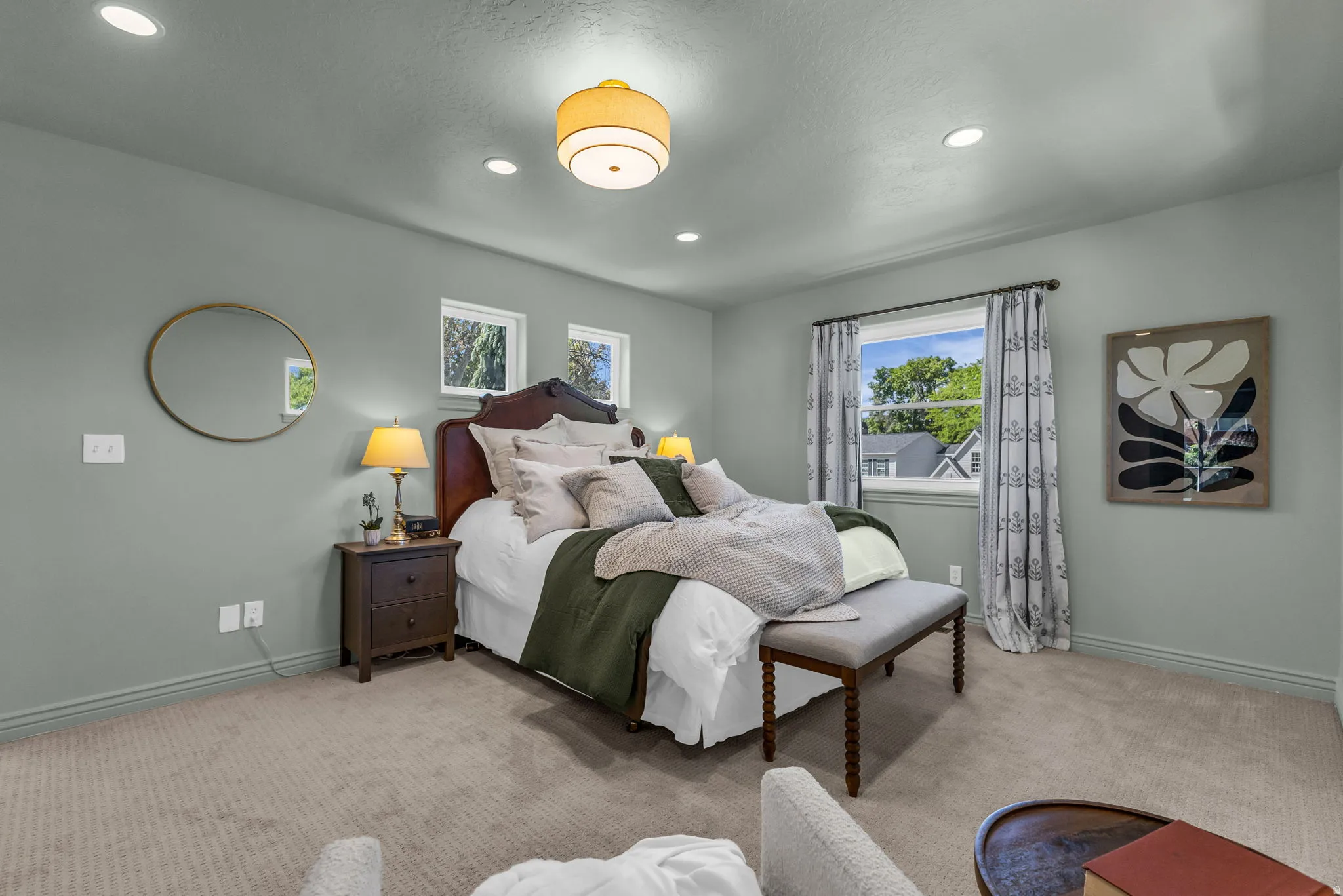 Spacious primary bedroom with bright tree-top views