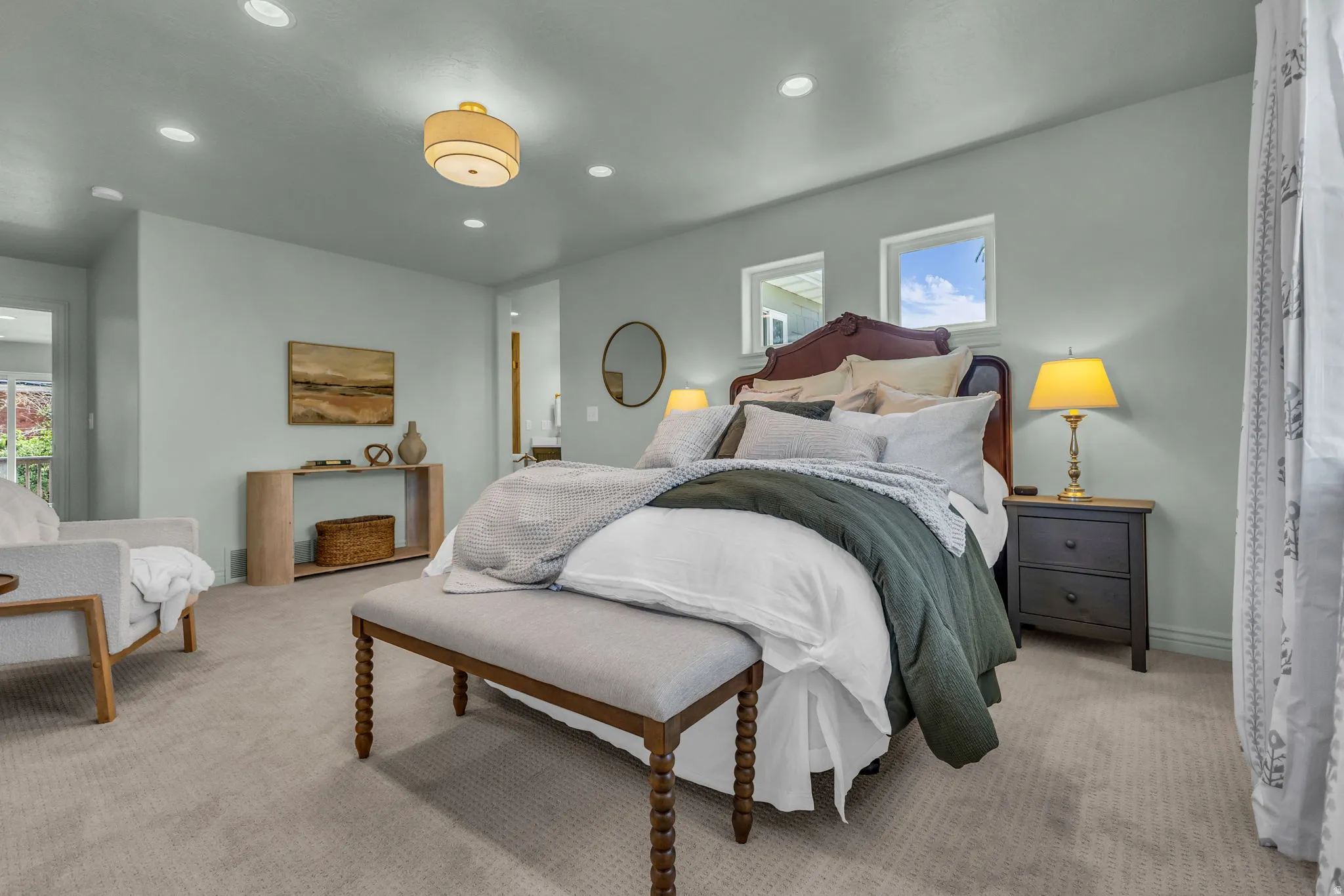 Spacious primary bedroom with bright tree-top views