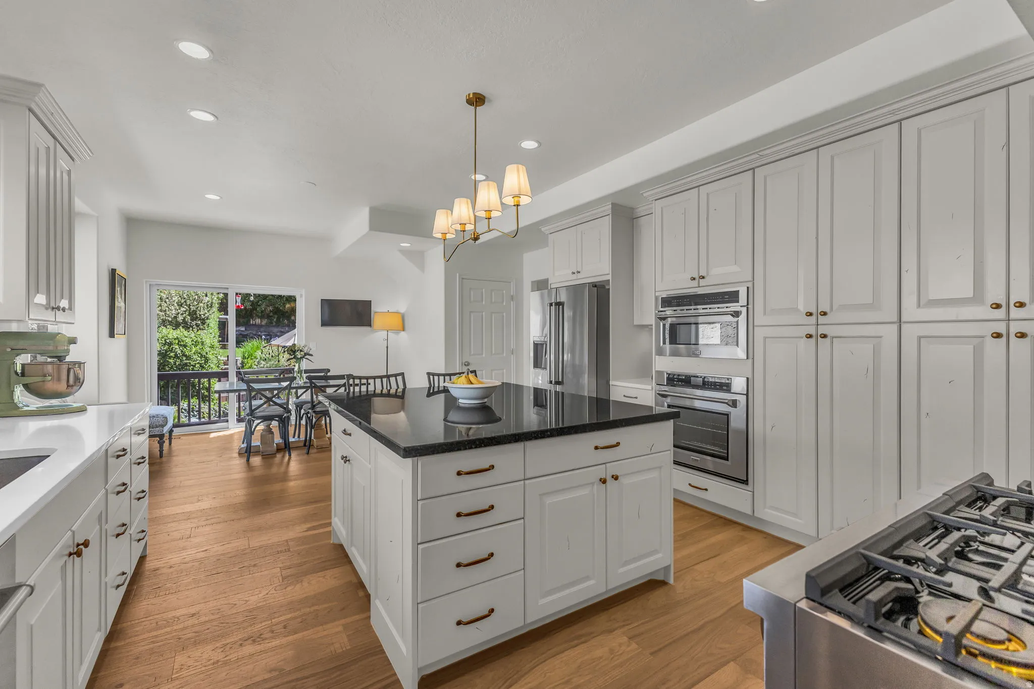 Spacious eat-in kitchen with granite and quartz, a hidden pantry, and a balcony to the backyard.