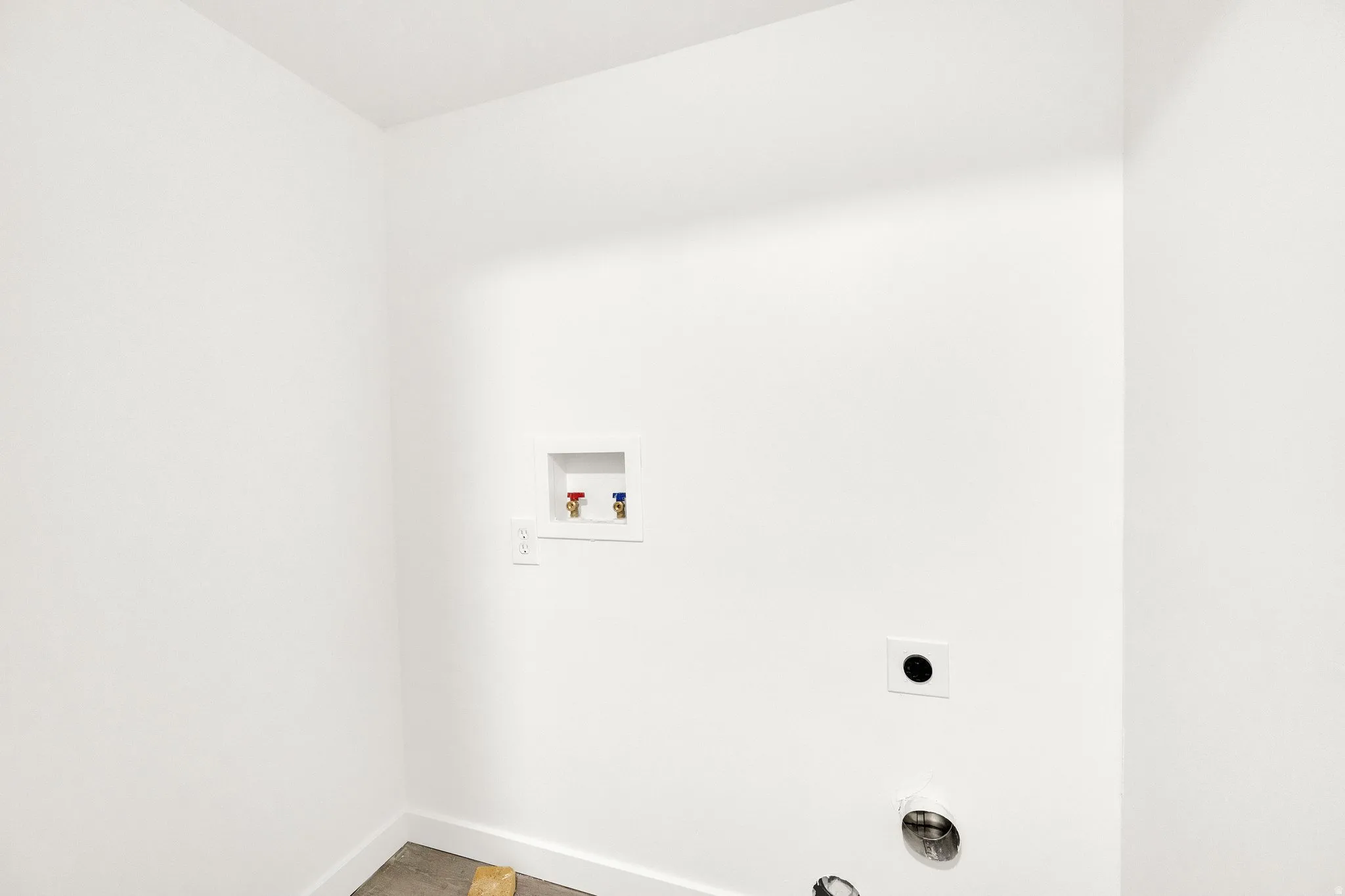 Dedicated utility space featuring white walls and baseboards