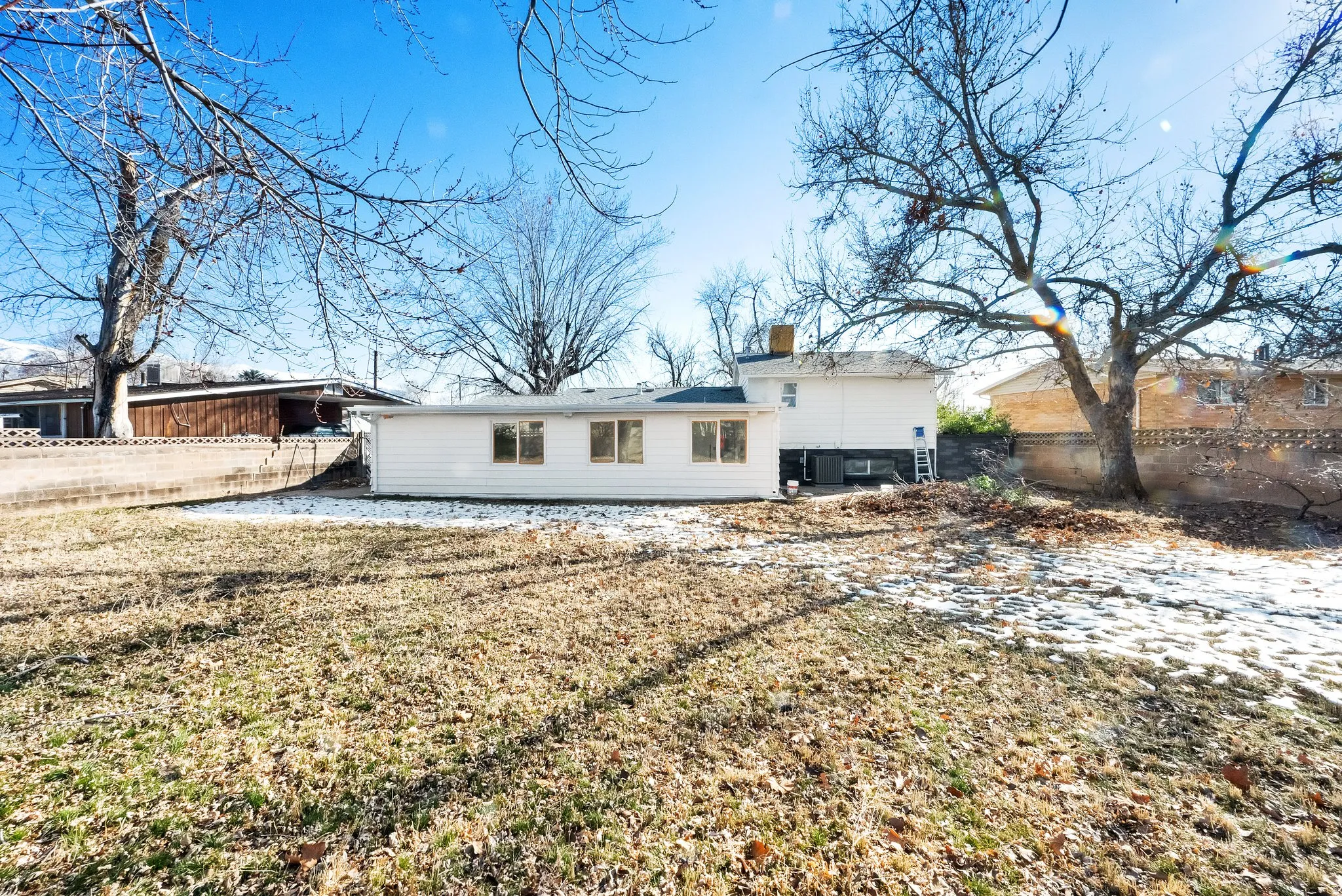 Expansive lawn area with a white exterior structure featuring multiple windows