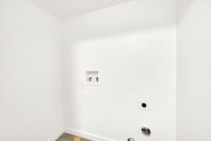Dedicated utility space featuring white walls and baseboards