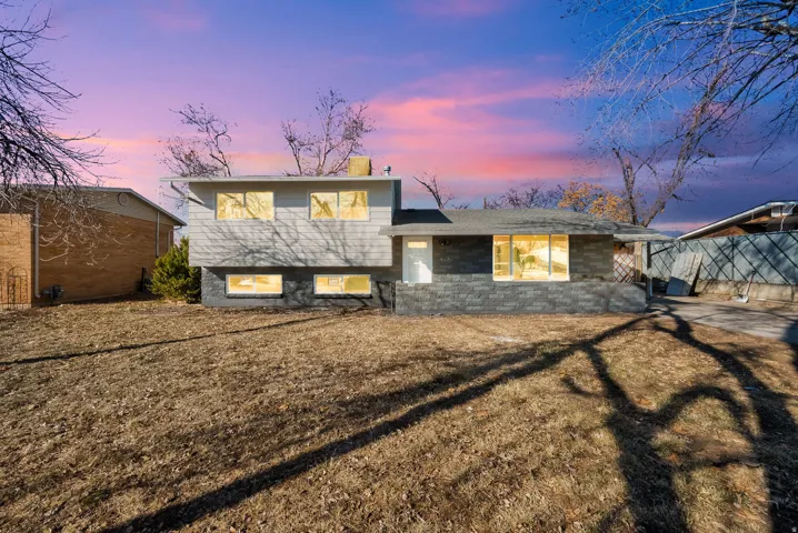 Split-level exterior featuring a combination of gray horizontal siding and dark gray brickwork