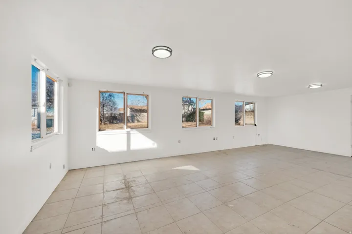 Spacious room featuring tile flooring, multiple windows, and recessed lighting fixtures