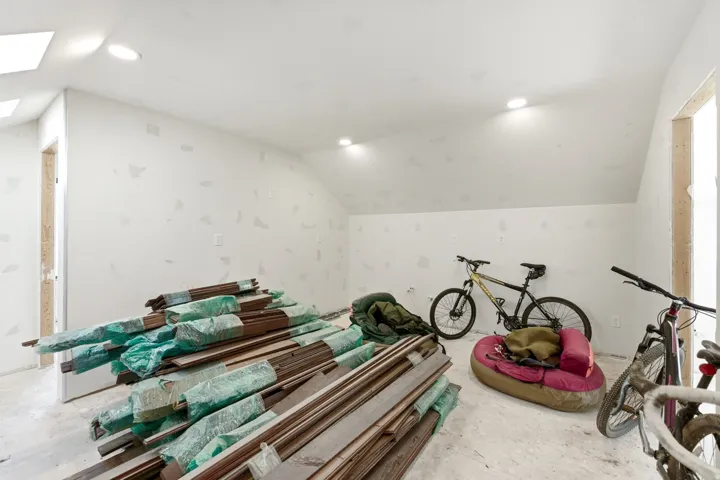 Expansive attic space featuring a sloped ceiling, recessed lighting, and a skylight