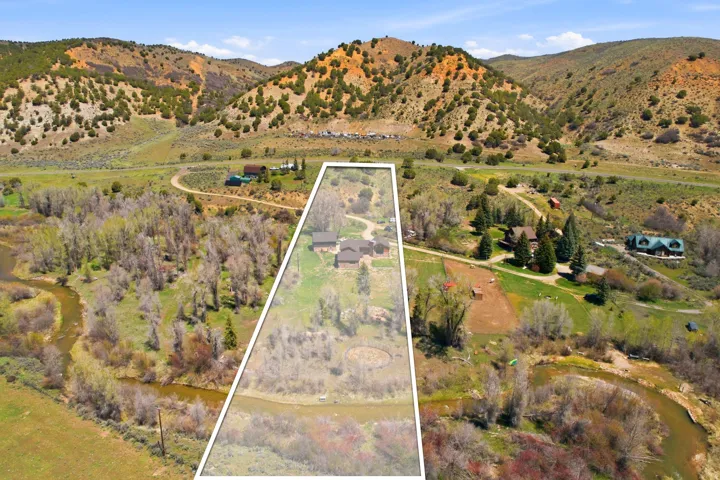 Expansive property featuring a winding river, mature trees, and mountainous terrain