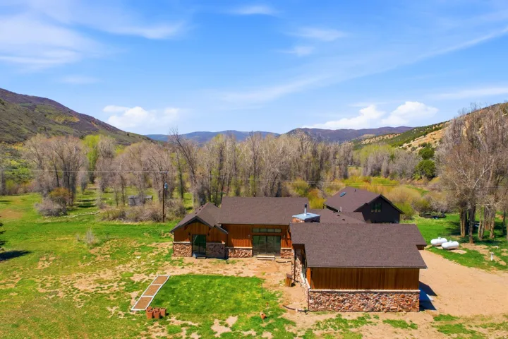 Expansive property featuring a multi-structure residence with wood siding and stone accents