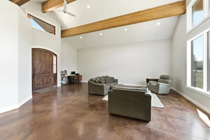 Vaulted ceiling great room featuring exposed wood beams, recessed lighting, and expansive windows