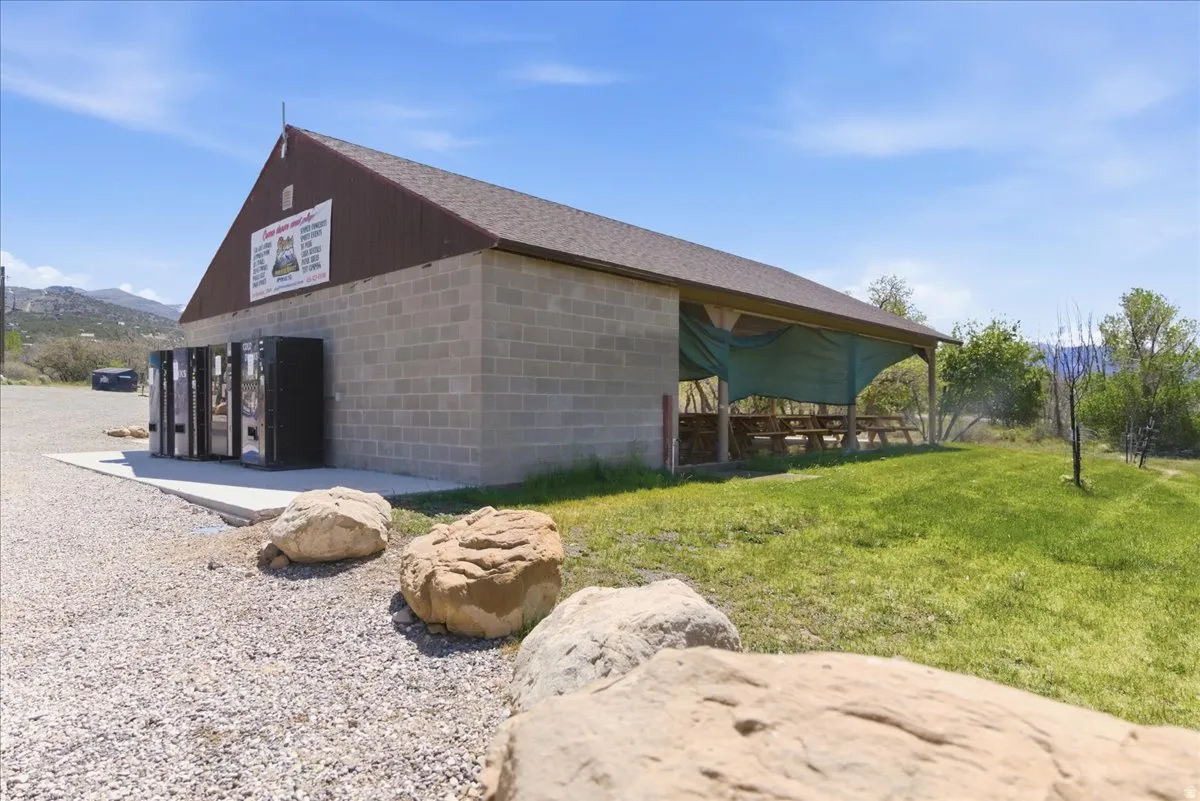 Gable-roof building featuring a block exterior and a side-covered patio area with picnic tables