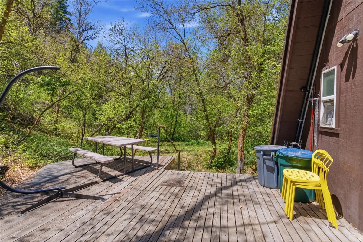 Expansive outdoor deck featuring wood planking and surrounding lush trees