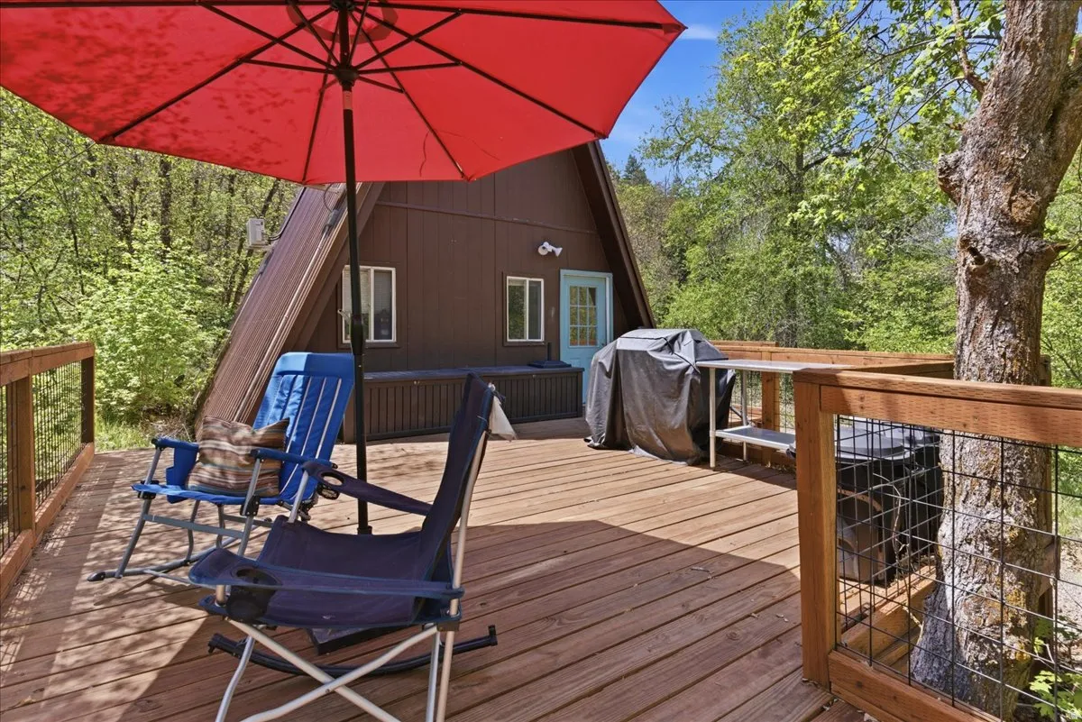 Expansive exterior deck featuring natural wood flooring and a sturdy wood railing with wire mesh infill
