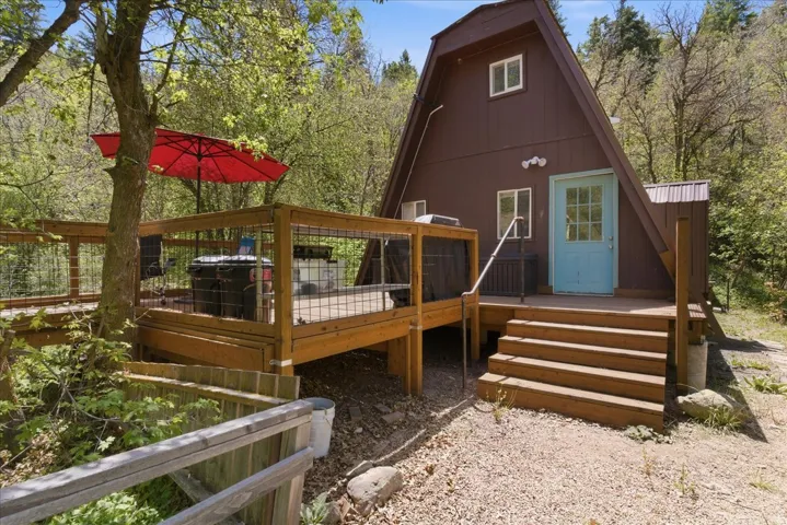 A-frame exterior with wood siding and a light blue entry door