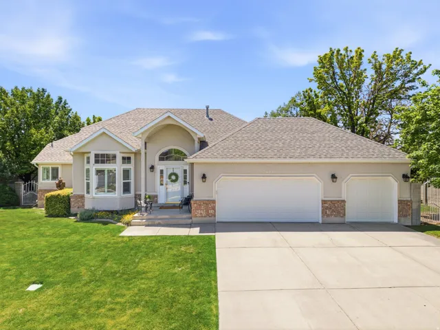 Stucco exterior featuring stone accents, a three-car garage, and a concrete driveway