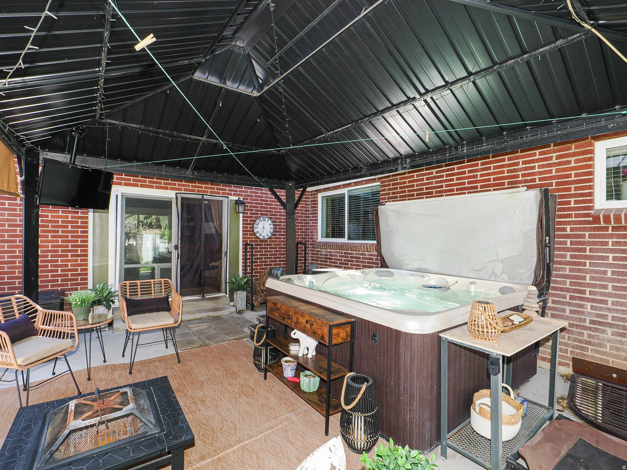 Patio off family room with hot tub and TV.
