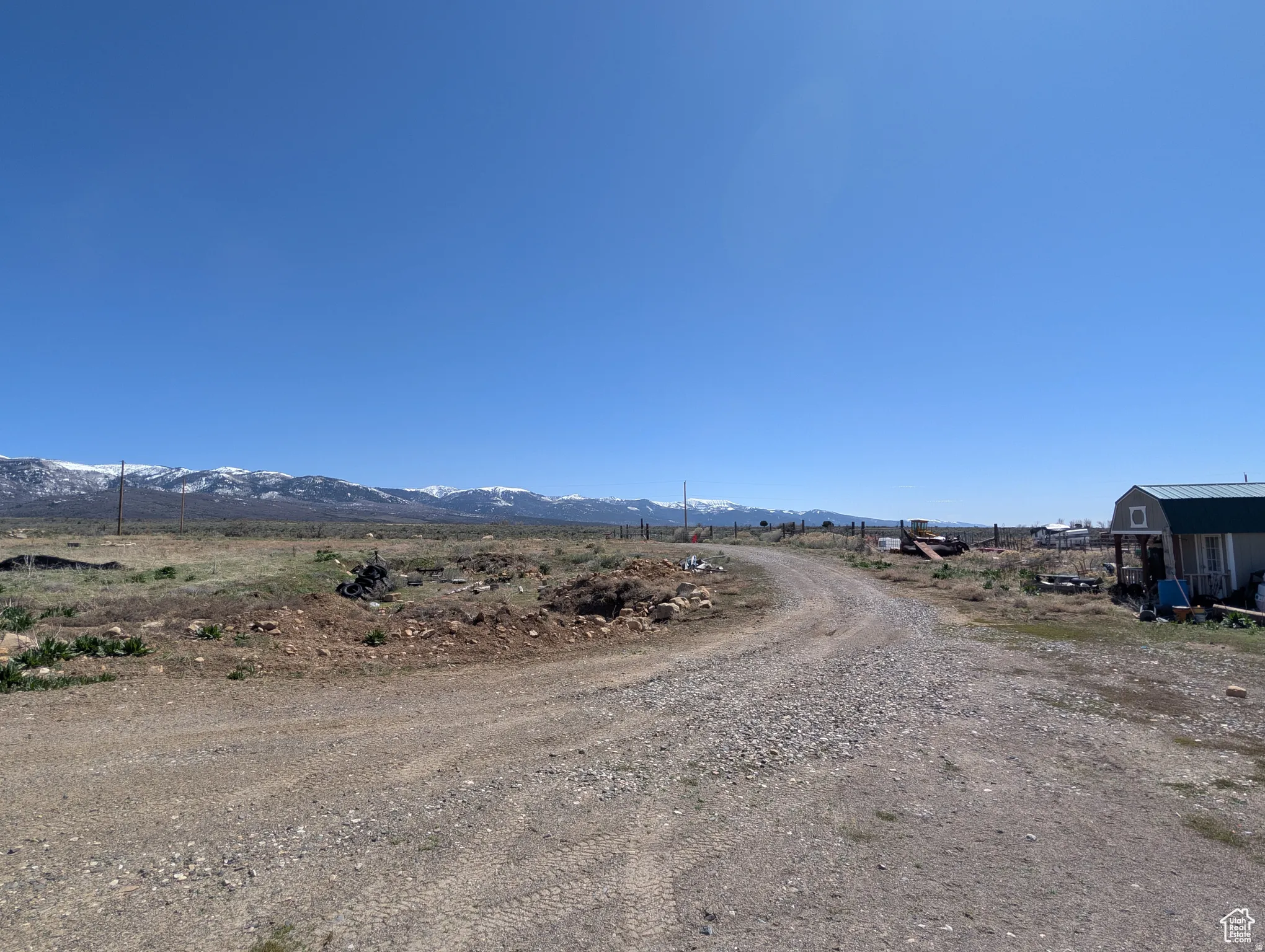 View of dirt / gravel road with a mountain view and a view of countryside