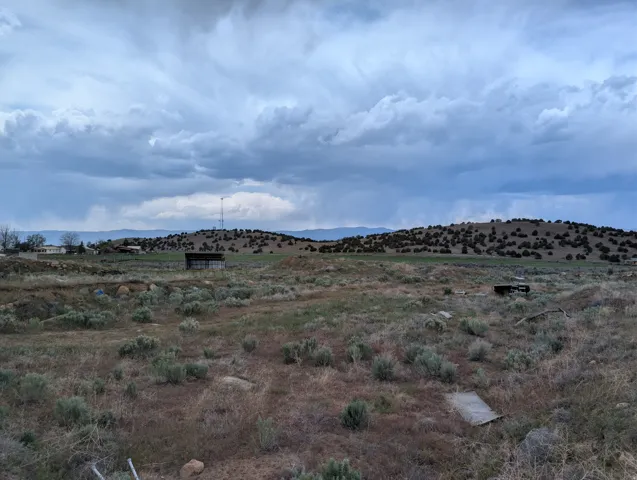 Expansive natural landscape featuring rolling hills and distant mountains