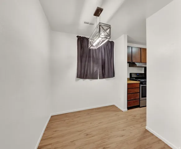 Dining area featuring wood-finish flooring and a rectangular metal chandelier