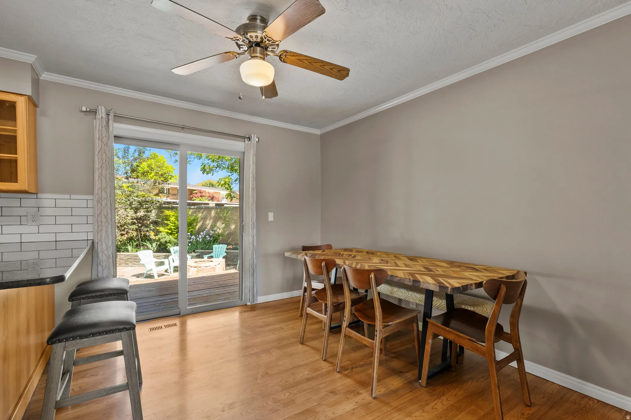 Hardwood-finish flooring throughout the dining area, featuring a ceiling fan with integrated lighting