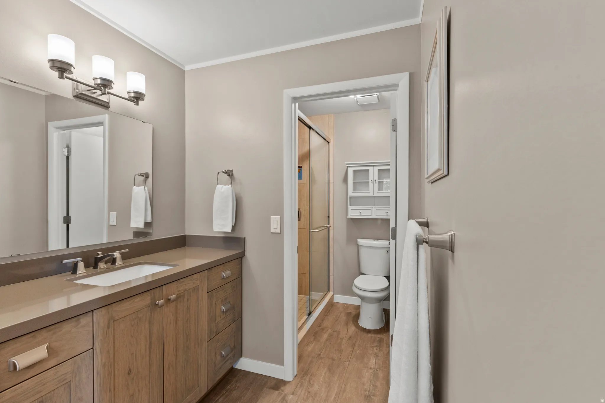 Bathroom with a wood-finish vanity and integrated sink