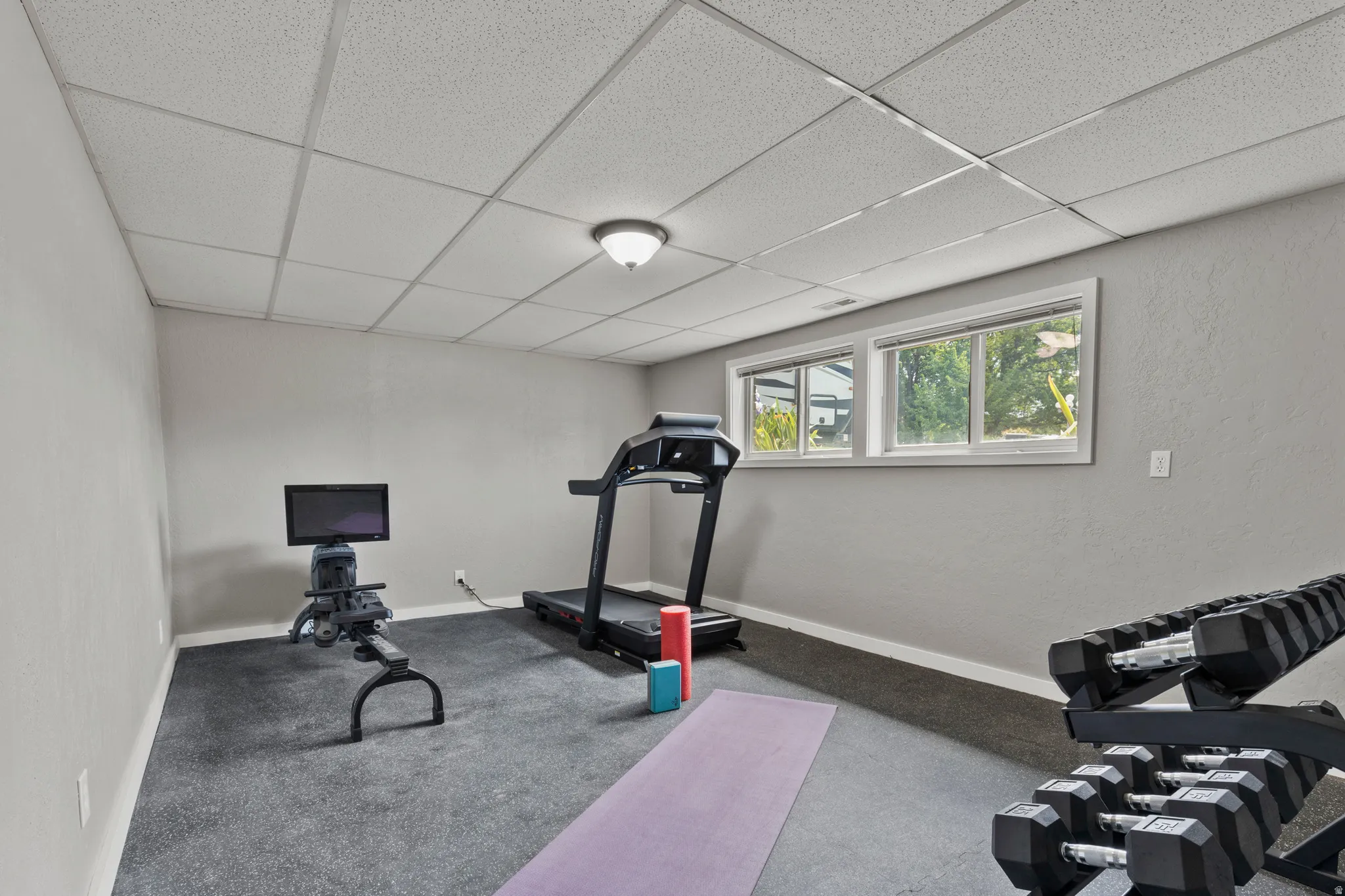 Finished interior space featuring two windows, recessed lighting, and a drop-tile ceiling