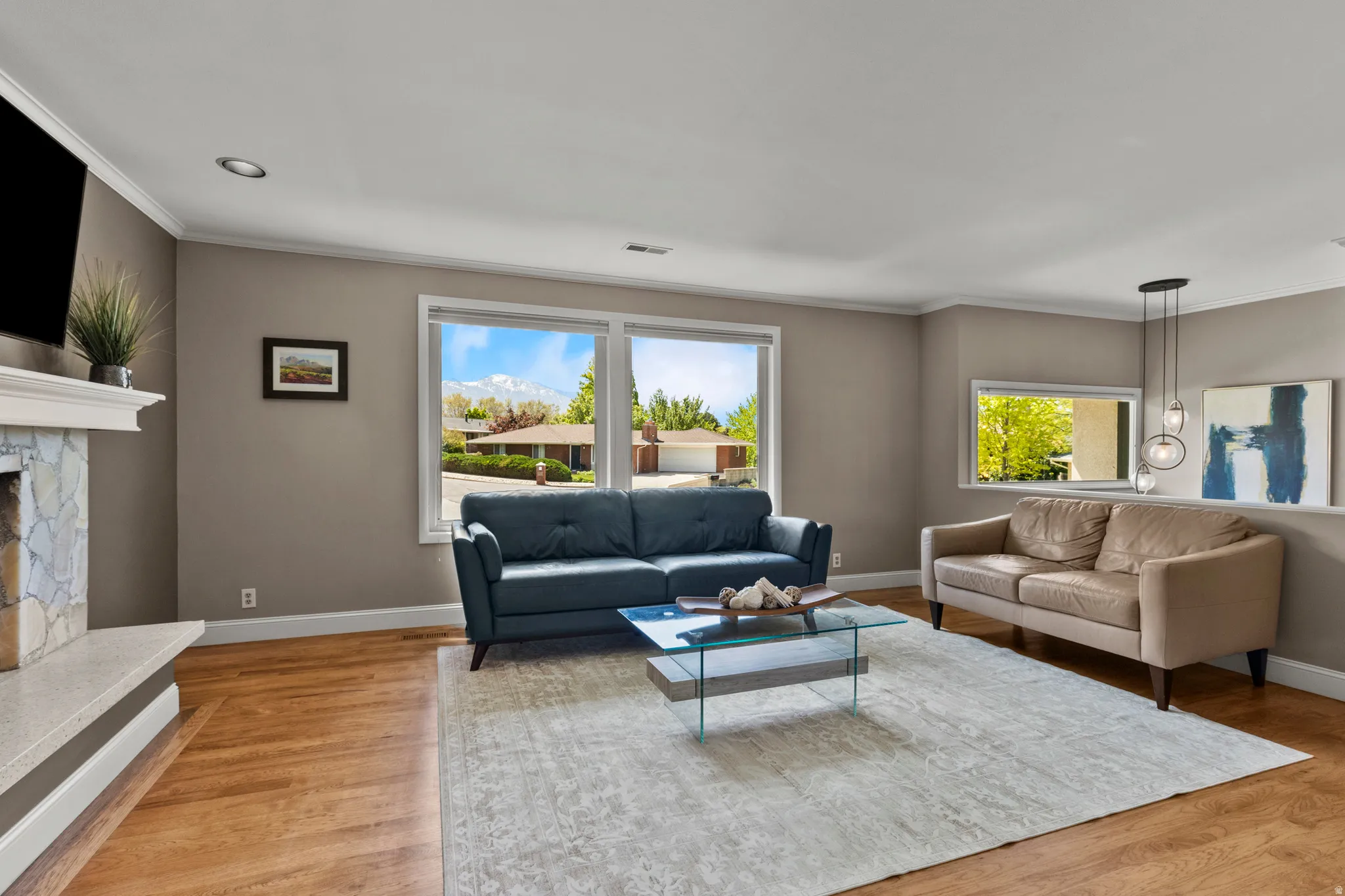 Living area with wood-finish flooring and crown molding
