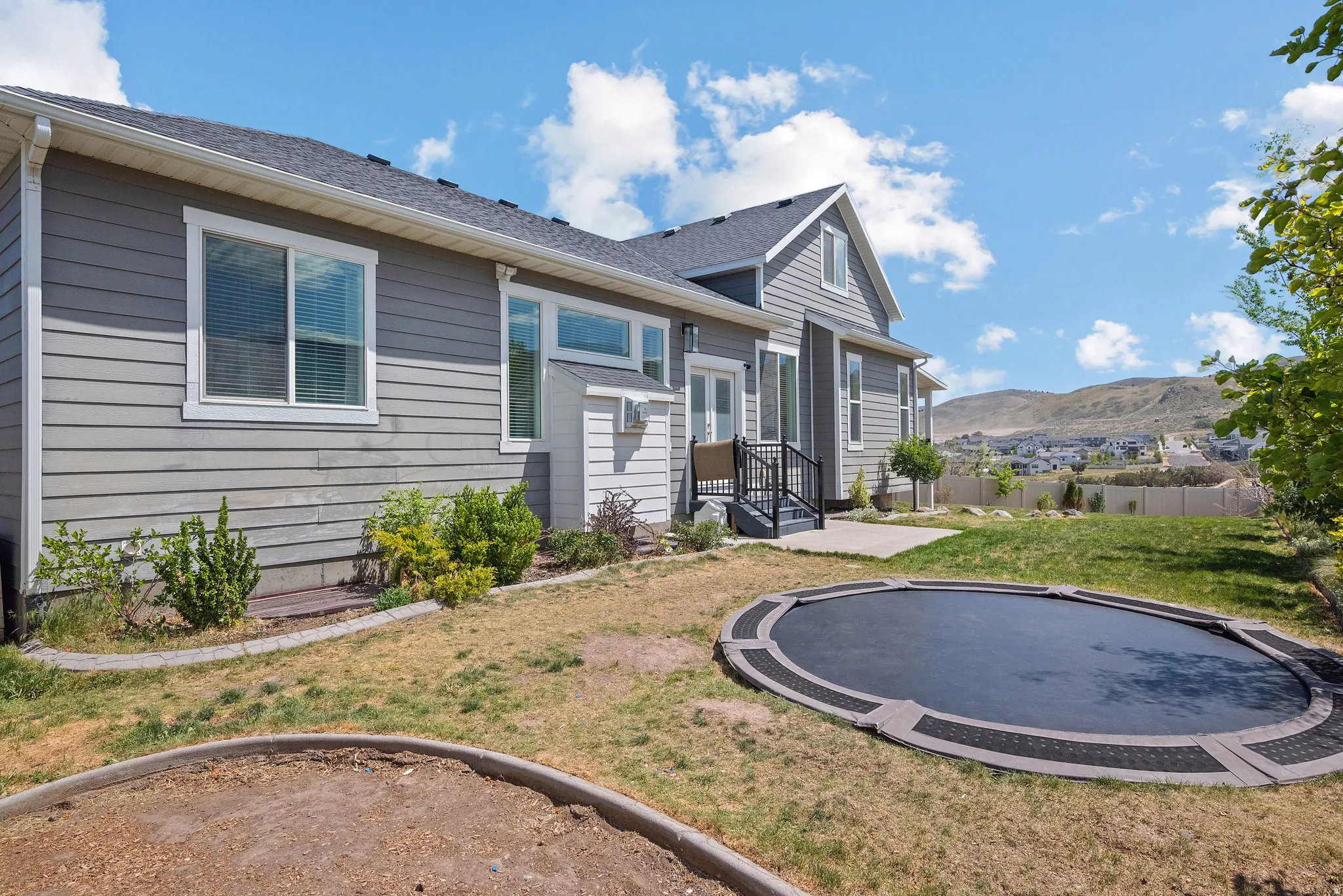 Gray siding exterior with white trim windows and a dark shingle roof