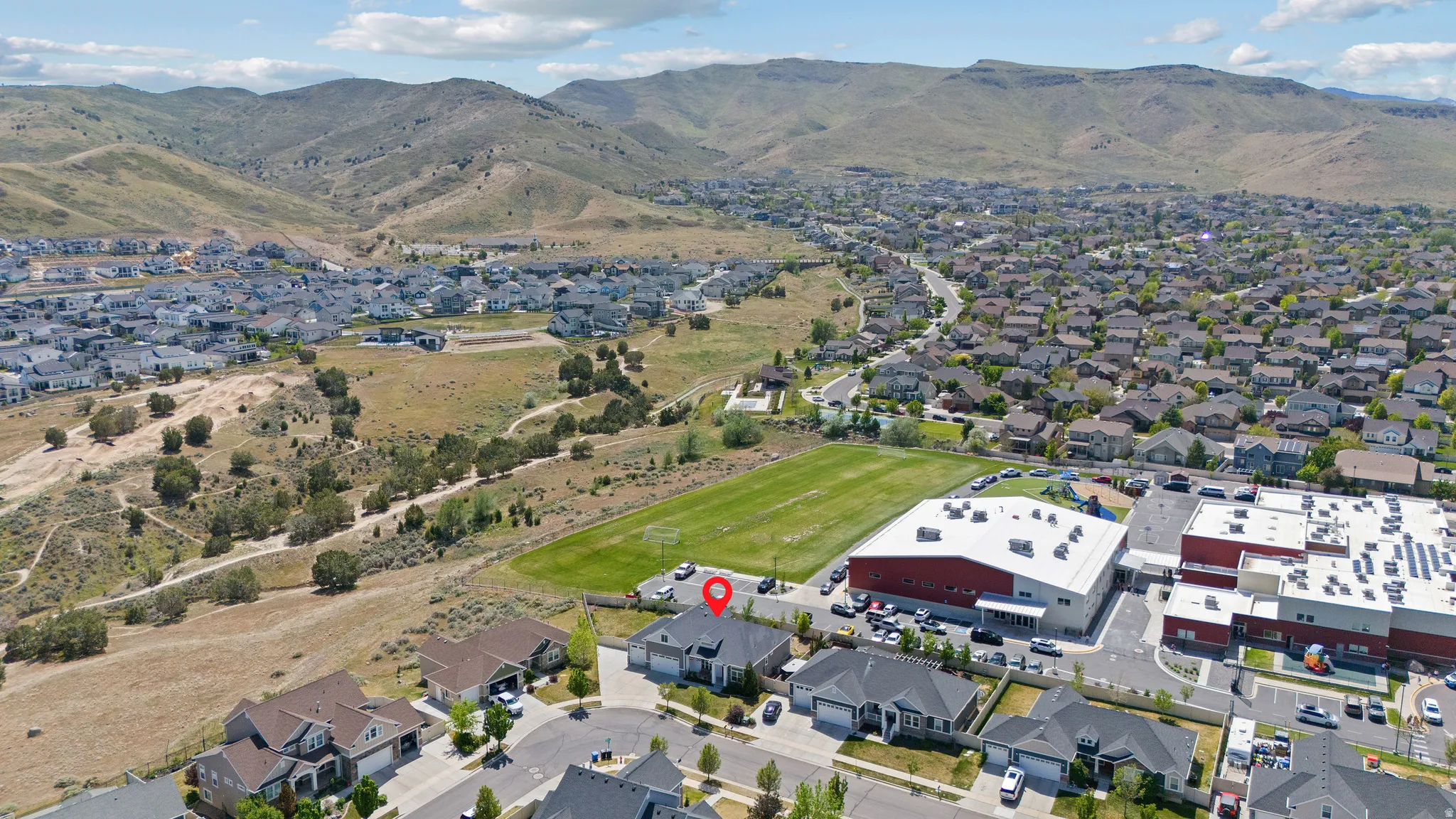 Residential area with extensive housing, adjacent to open fields and natural terrain