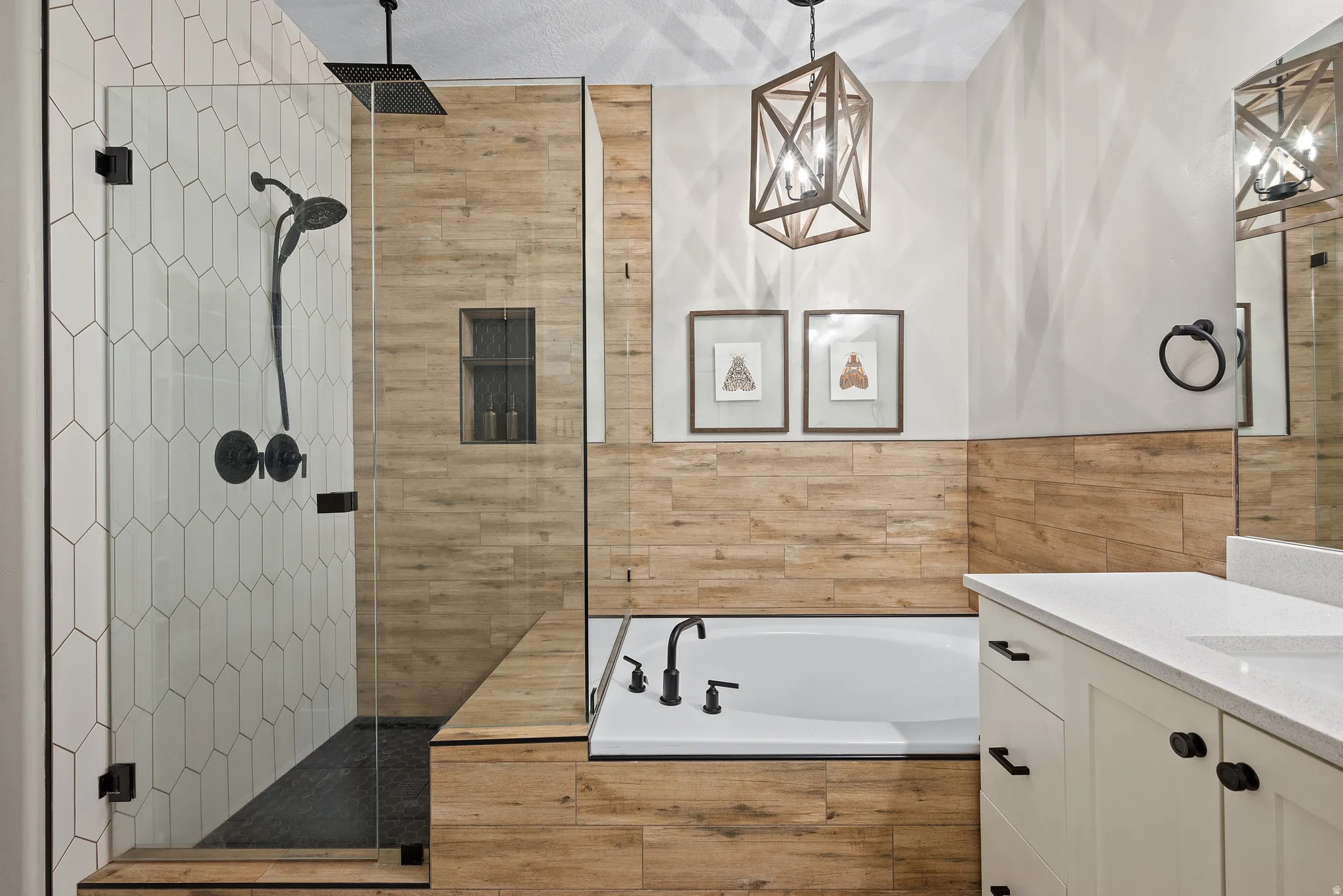 Bathroom featuring a glass-enclosed shower with elongated hexagonal tile and a built-in shower niche