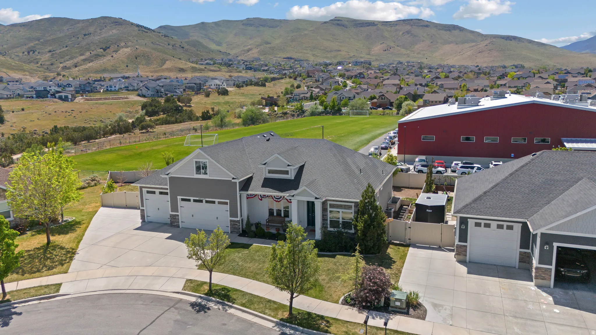 Contemporary residence featuring a multi-gable roofline, a triple garage, and stone accent siding