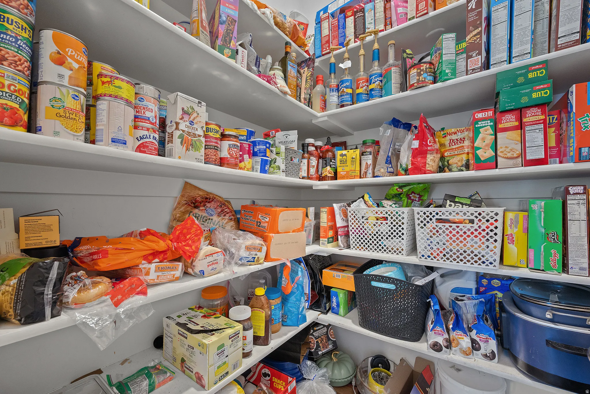 Spacious pantry featuring multiple tiers of built-in shelving, providing extensive storage capacity